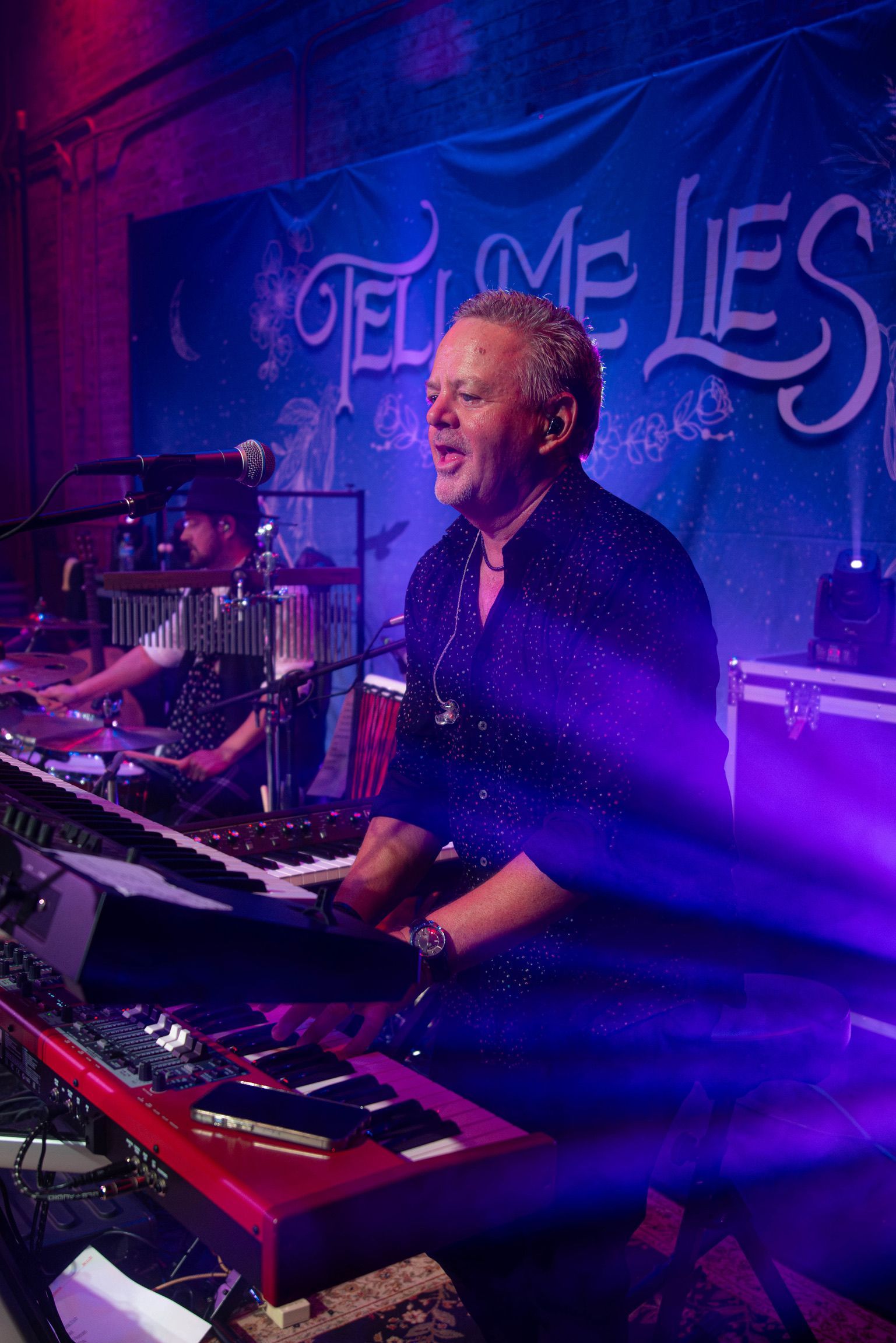 Man playing keyboard on stage with 
