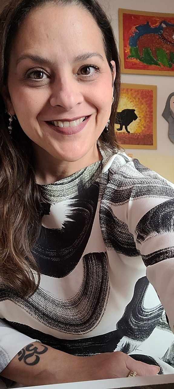 Mujer en traje de negocios sosteniendo una computadora portátil con gráficos coloridos, sonriendo.