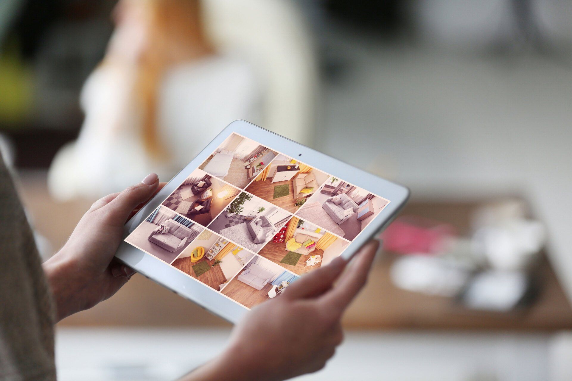 Hand holding a tablet showing security camera footages