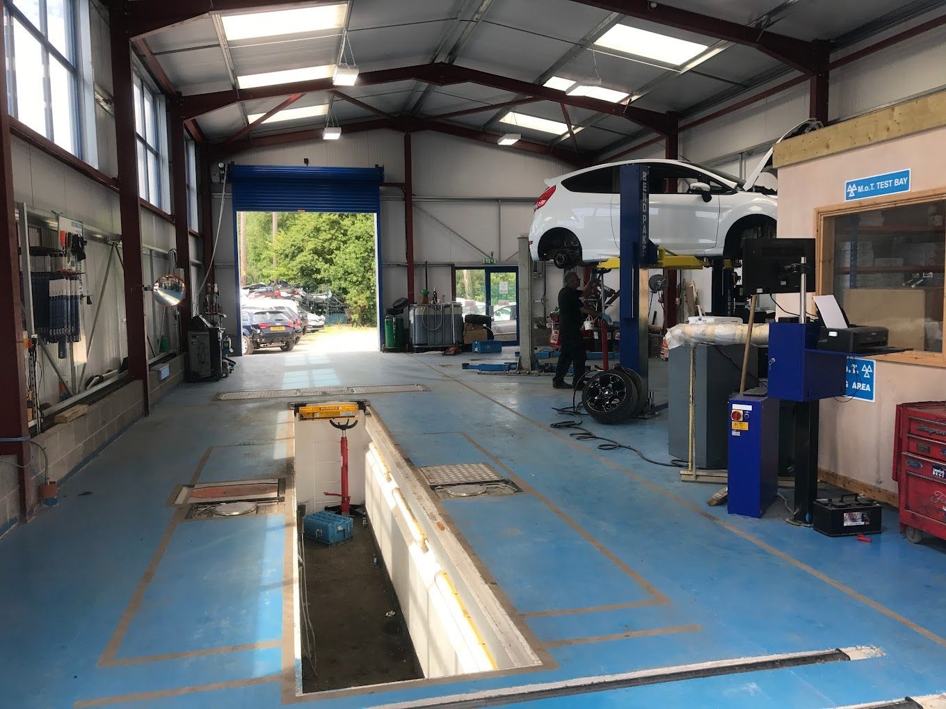 UK Select Accident Repair Centres | A car is sitting on a lift in a garage.