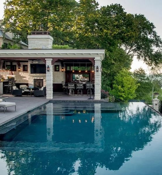 A house with a large swimming pool in front of it