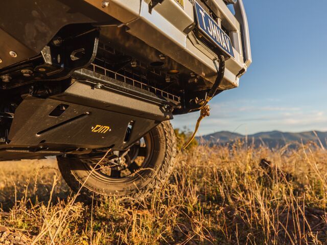 A Car is Parked in a Field of Tall Grass With Mountains — TJM Dubbo In Dubbo, NSW