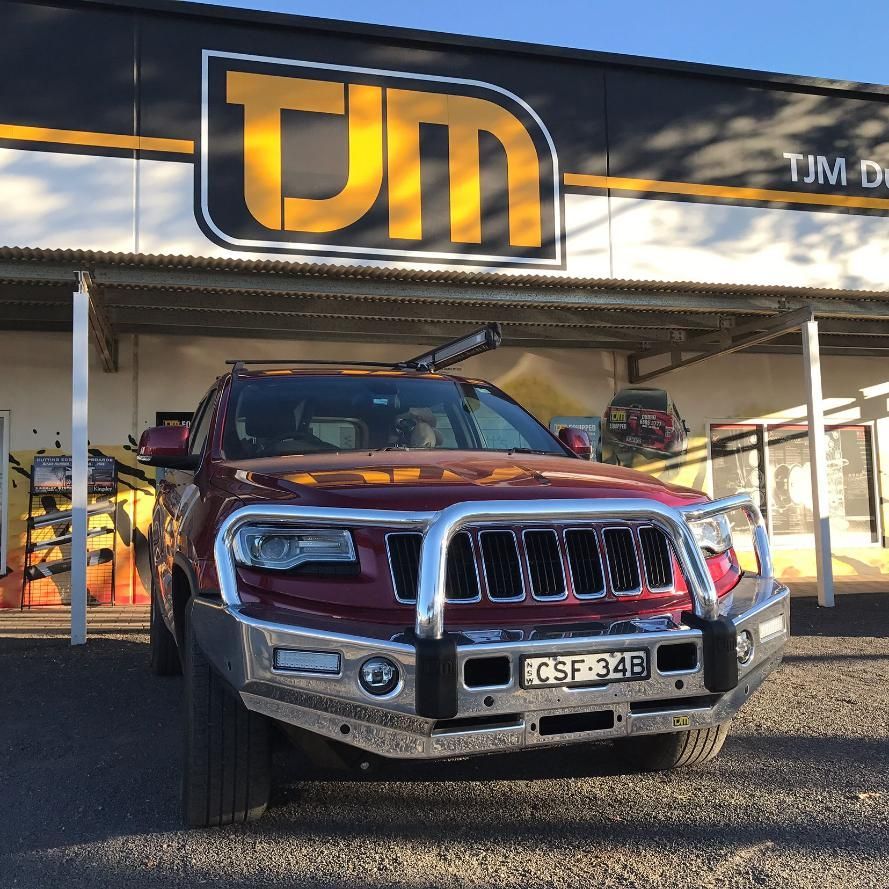 A Red Truck Is Parked In Front Of A TJM Store — TJM Dubbo In Wellington, NSW