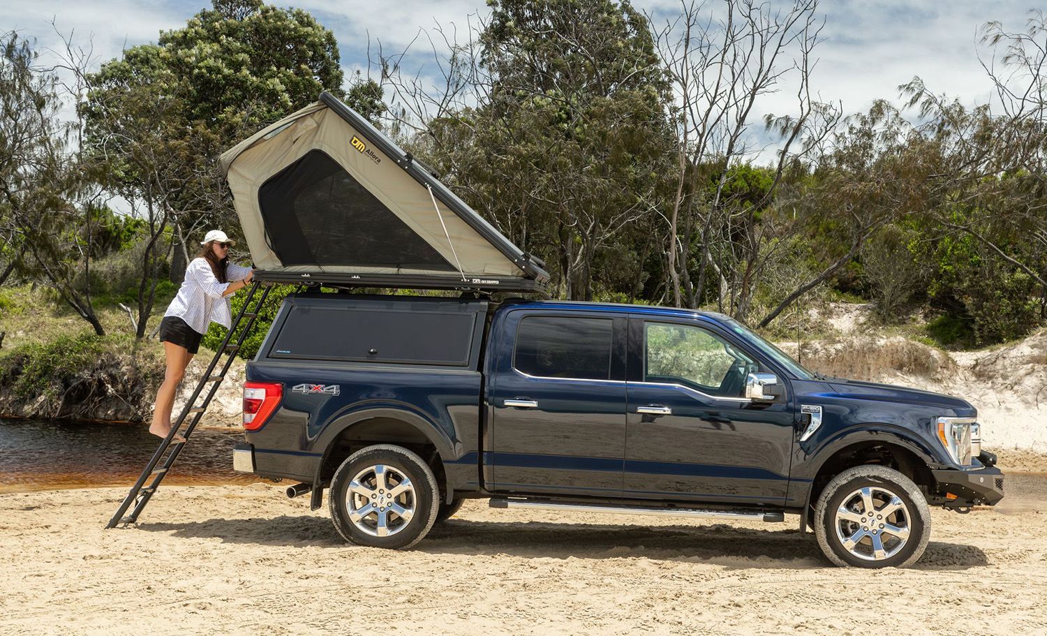 A UTE Fitted With A Canopy And Rooftop Tent Parked On A Sandy Beach