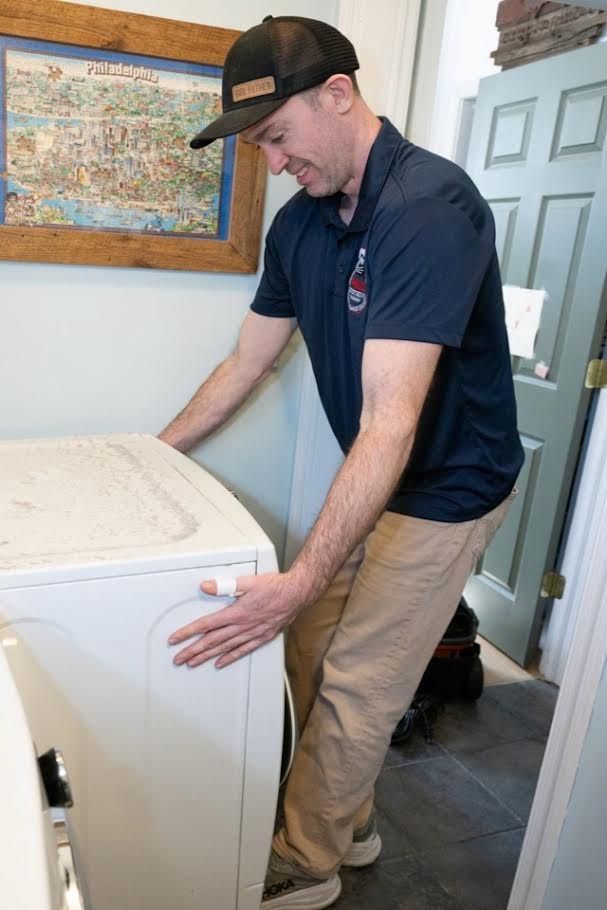 Man in blue shirt doing dryer vent inspection