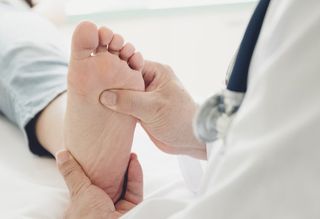 Doctor Checking Patient's Foot — Pensacola, FL — Pensacola Podiatry P.A.