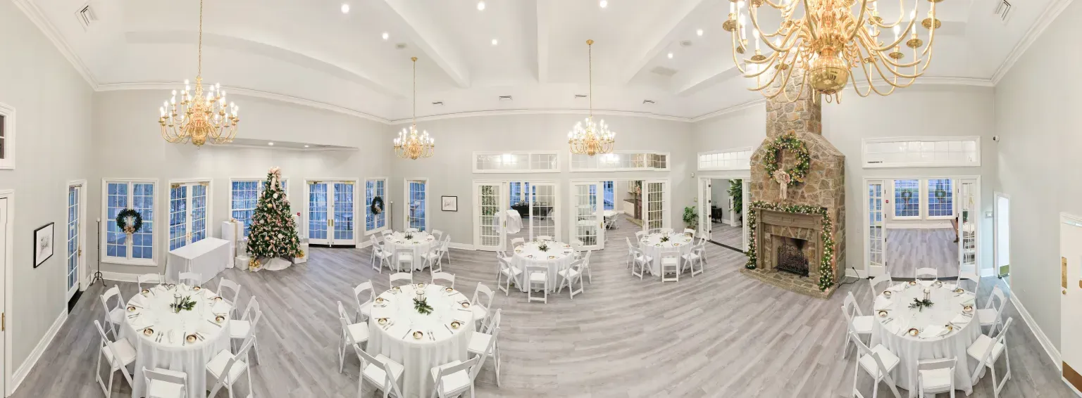 A large room filled with tables and chairs and a fireplace.