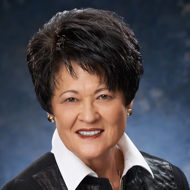 A woman with short black hair is smiling for the camera