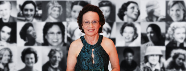 A woman stands in front of a wall of women 's faces