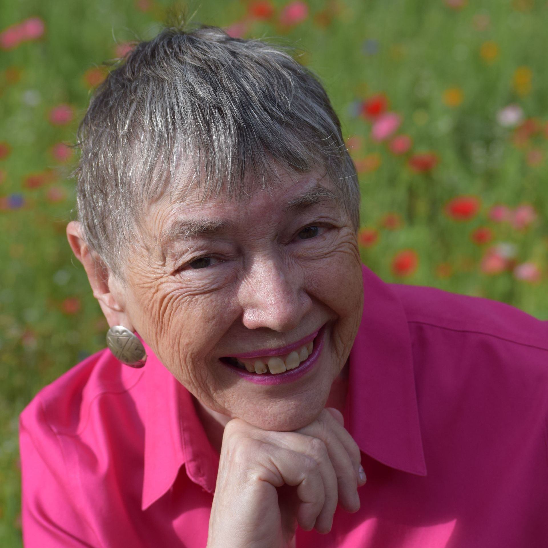 A woman wearing glasses and a black shirt smiles for the camera