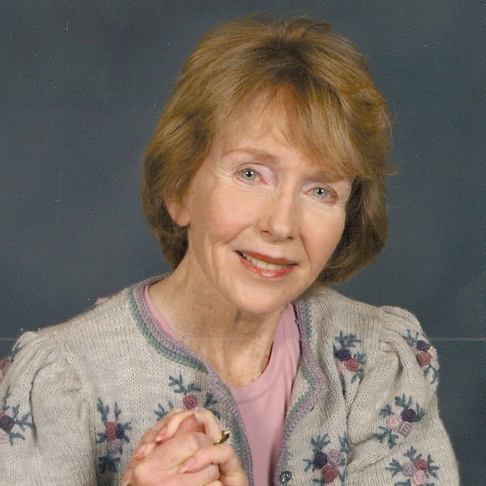 An older woman wearing a black shirt with flowers on it