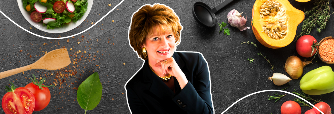 A woman is surrounded by vegetables and a bowl of salad