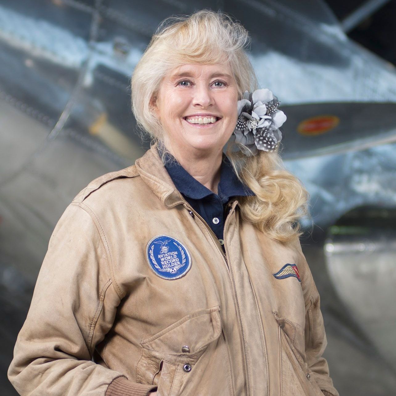 A woman wearing a tan jacket with a patch on it that says ' united states air force '