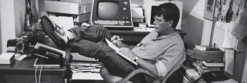 A man is sitting in a chair with his feet up in front of a computer.