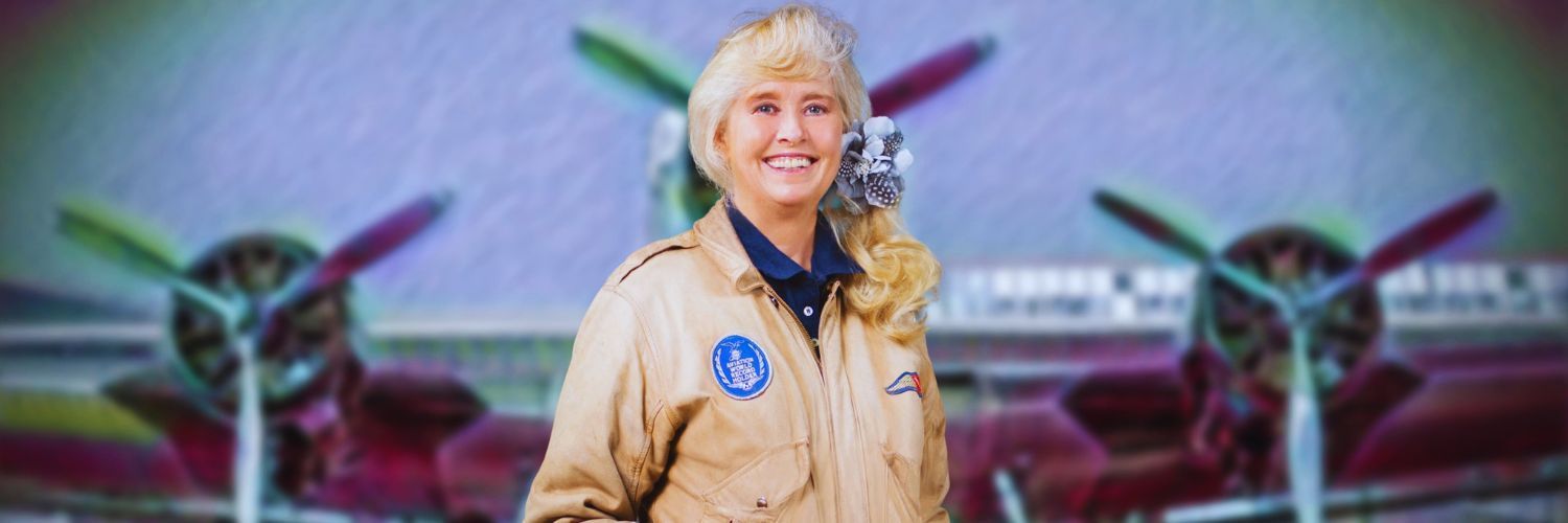 A woman in a ge uniform stands in front of an airplane