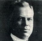 A black and white photo of a man in a suit and tie.