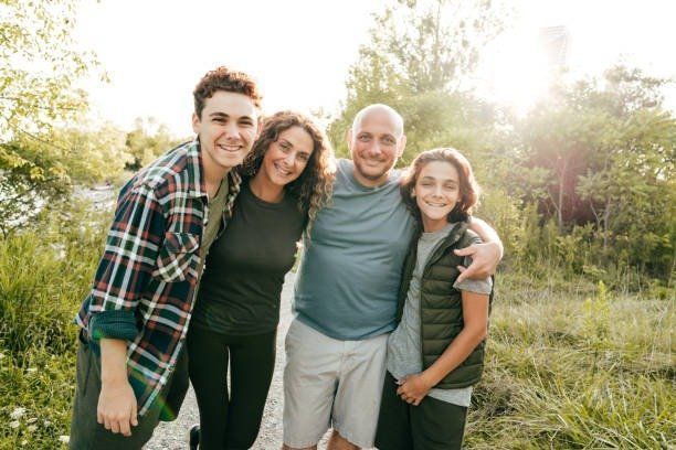 A family is posing for a picture together in a field.