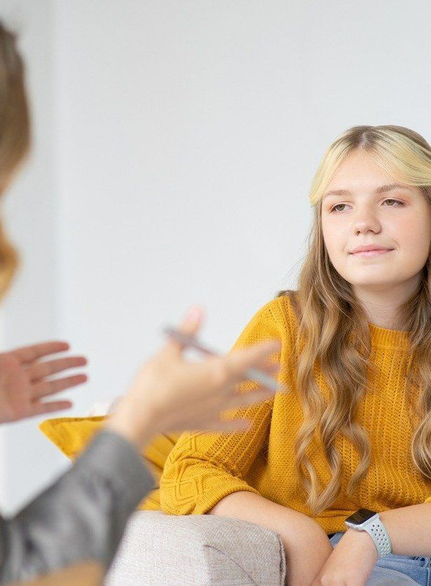 A Woman in a Yellow Sweater is Sitting on a Couch Talking to Another Woman — Albuquerque, NM — NewView Healing