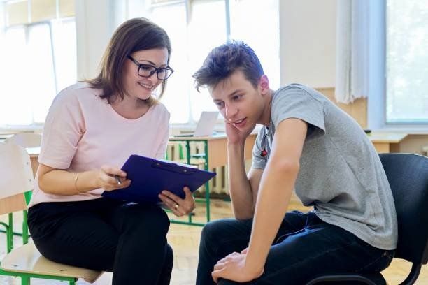 A Woman is Sitting Next to a Boy in a Chair and Looking at a Clipboard — Albuquerque, NM — NewView Healing