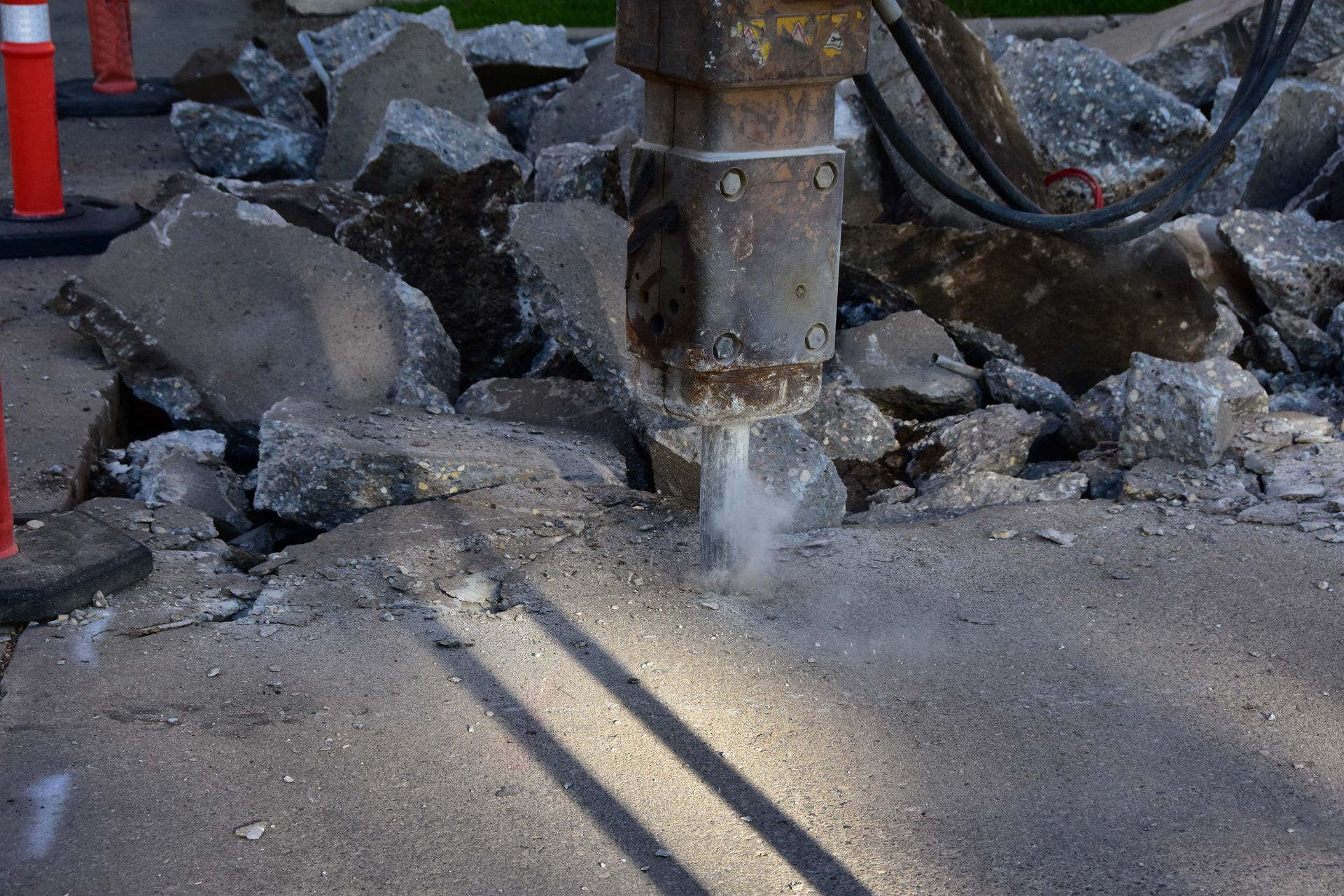 Mud jacking equipment drilling into cracked concrete slab during leveling repair process.