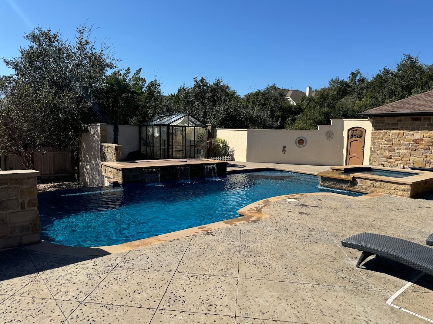 A large swimming pool is in the backyard of a house