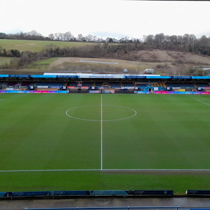 An aerial view of a soccer field with a stadium in the background.