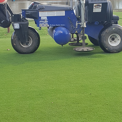 Two tractors are sitting on top of a lush green field.