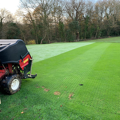 A tractor is sitting on top of a lush green field.