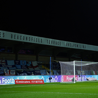A soccer field with advertisements for emirates fly better