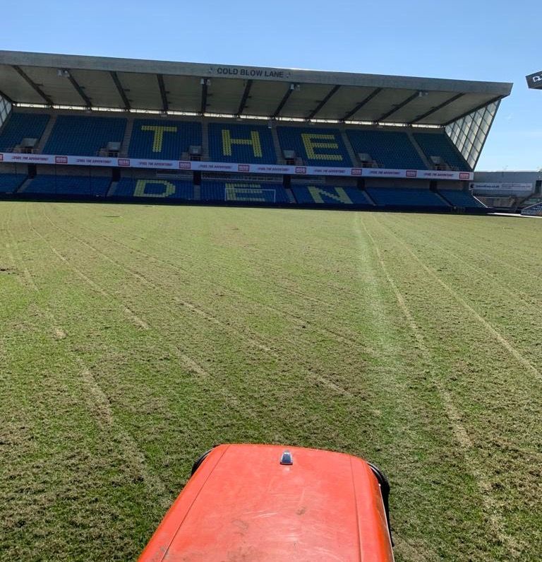 A tractor is parked in front of a stadium that says the den
