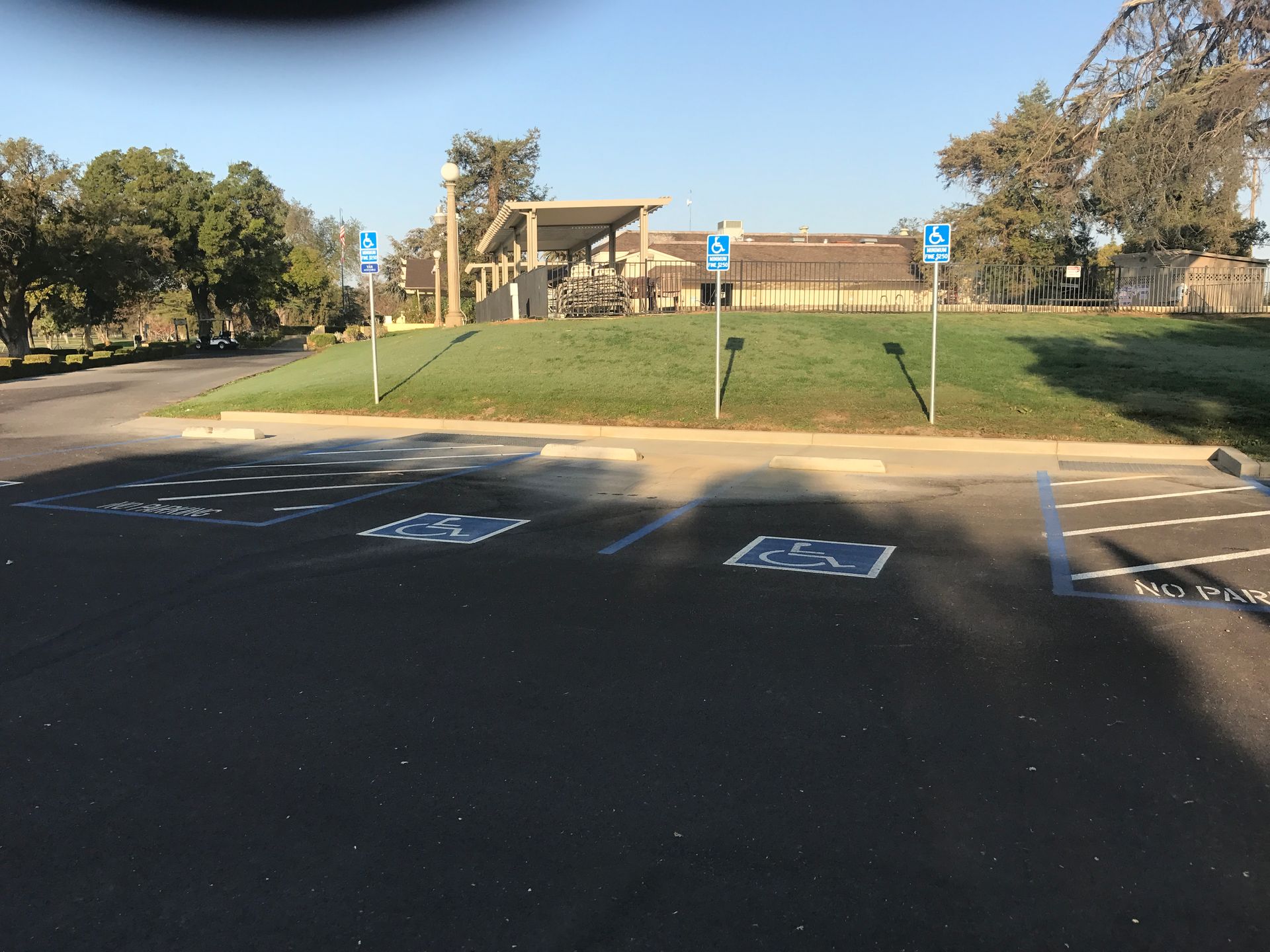 A parking lot with handicapped parking spaces and a building in the background