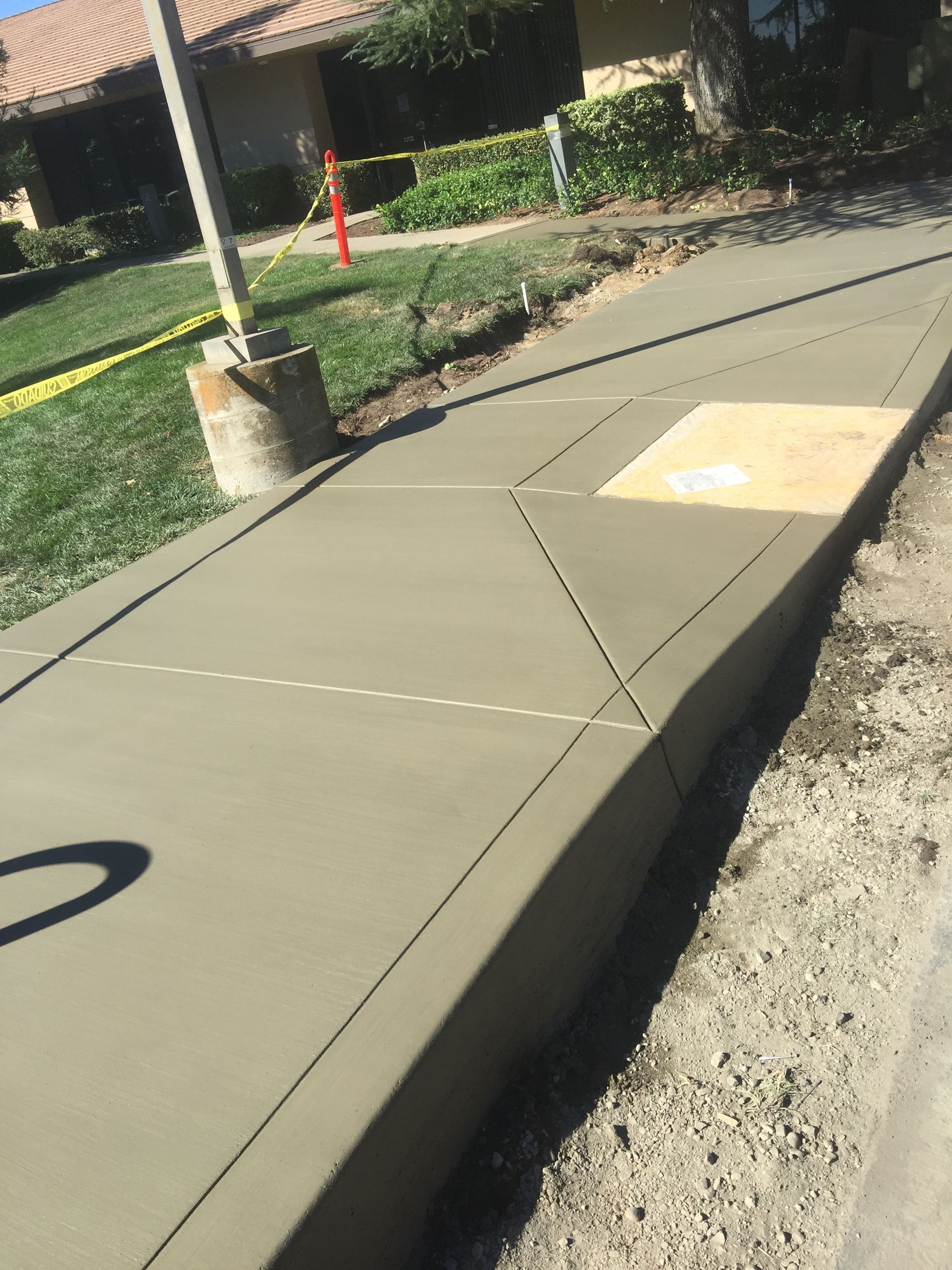 A concrete walkway is being built in front of a house.