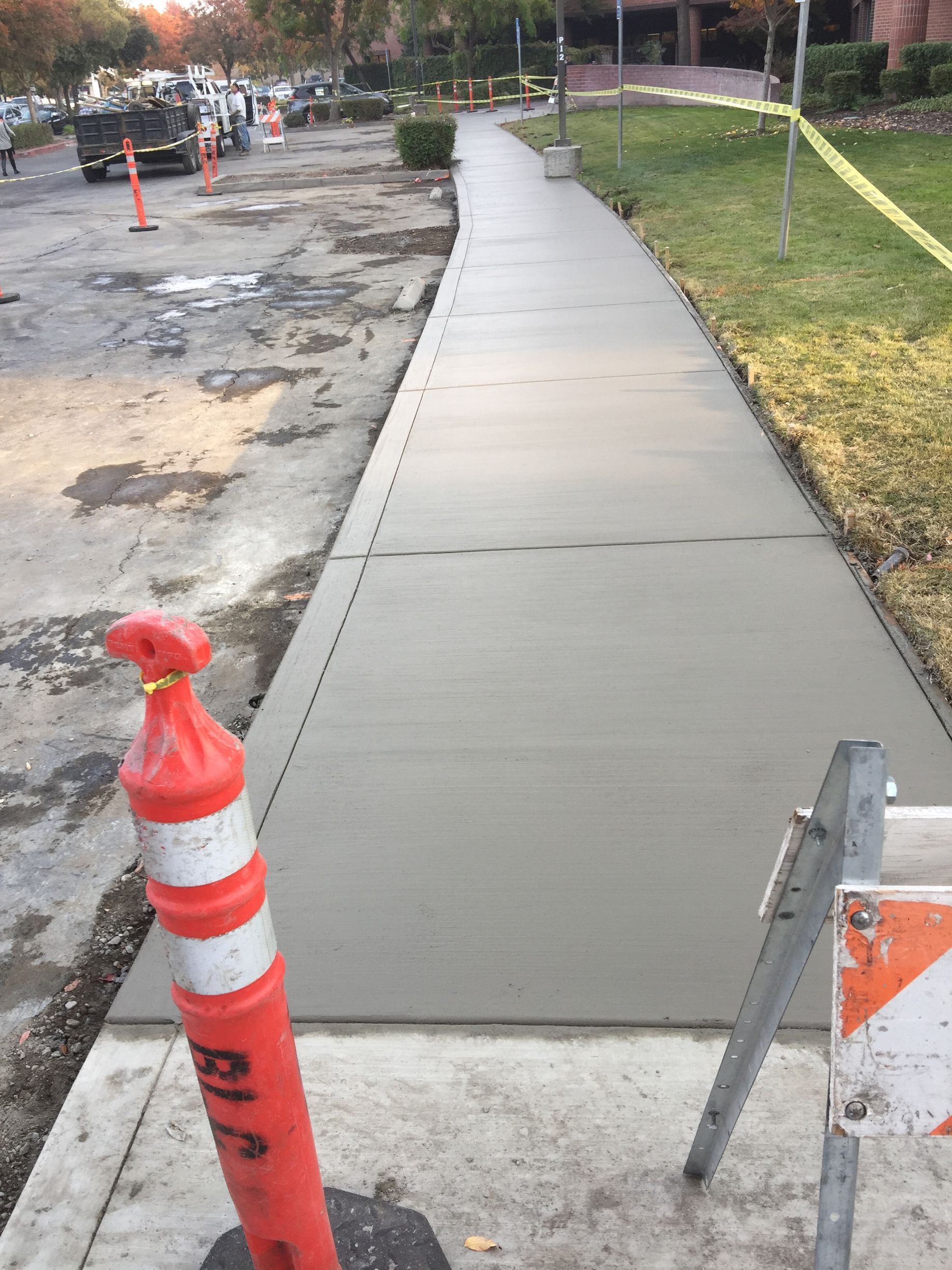 A concrete sidewalk is being built on the side of the road