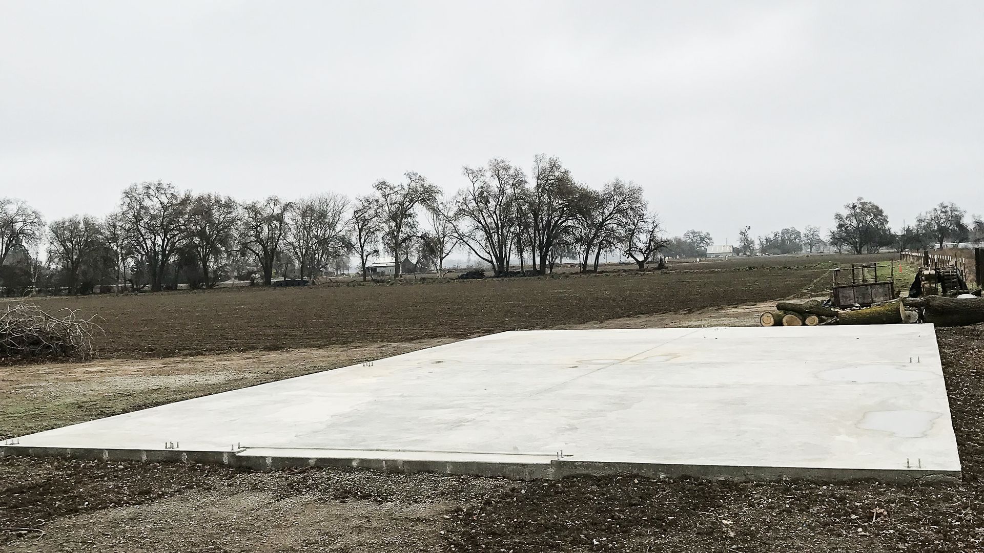 A large concrete slab is sitting in the middle of a field.