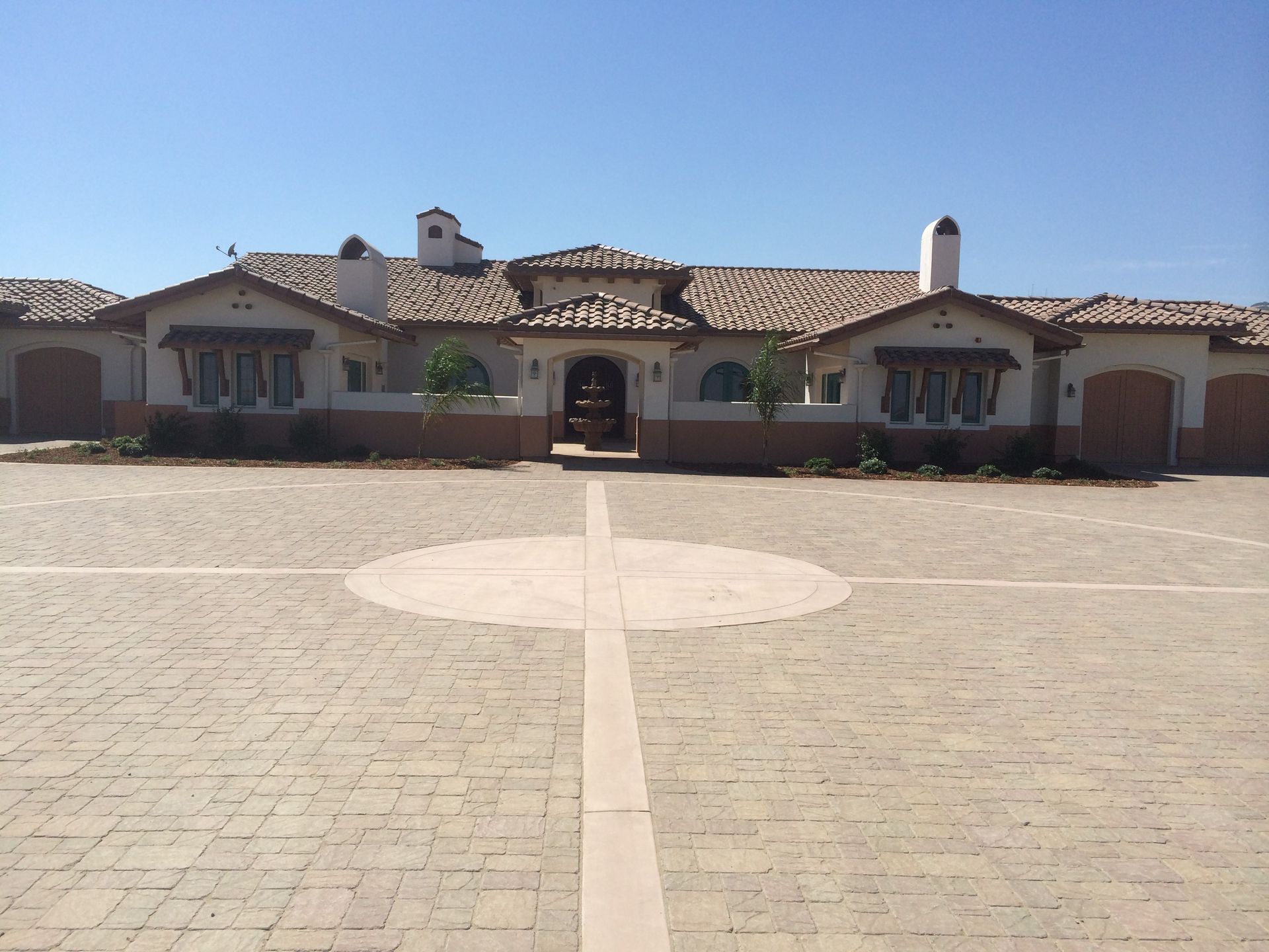 A large house with a brick driveway in front of it