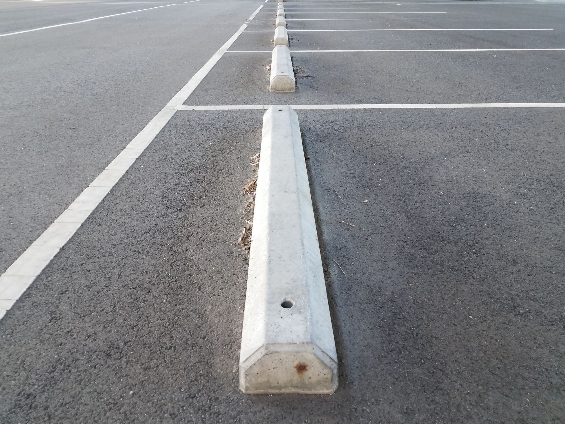 A row of concrete parking blocks in an empty parking lot