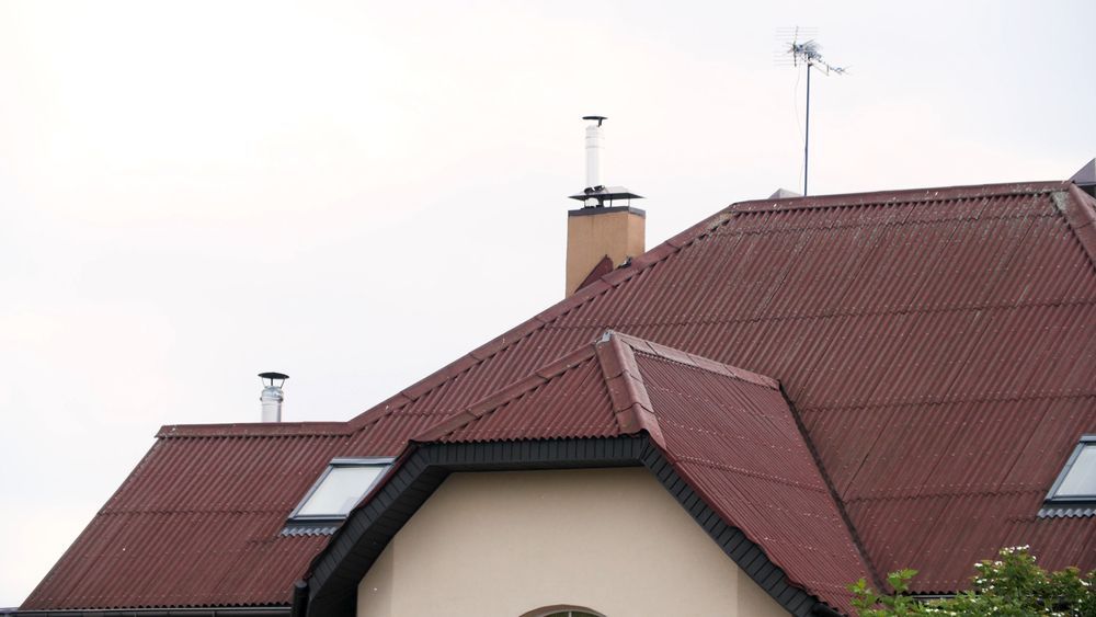 Red Corrugated Roof of a House With Chimneys — C&A Roofing In Tamworth, NSW