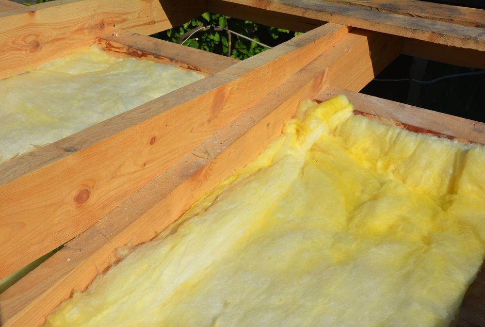 Wooden Roof Framing With Yellow Insulation Between Beams — C&A Roofing In Taree, NSW