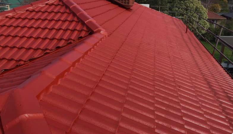Red tile roof of a house with visible ridge caps, clean and freshly painted.