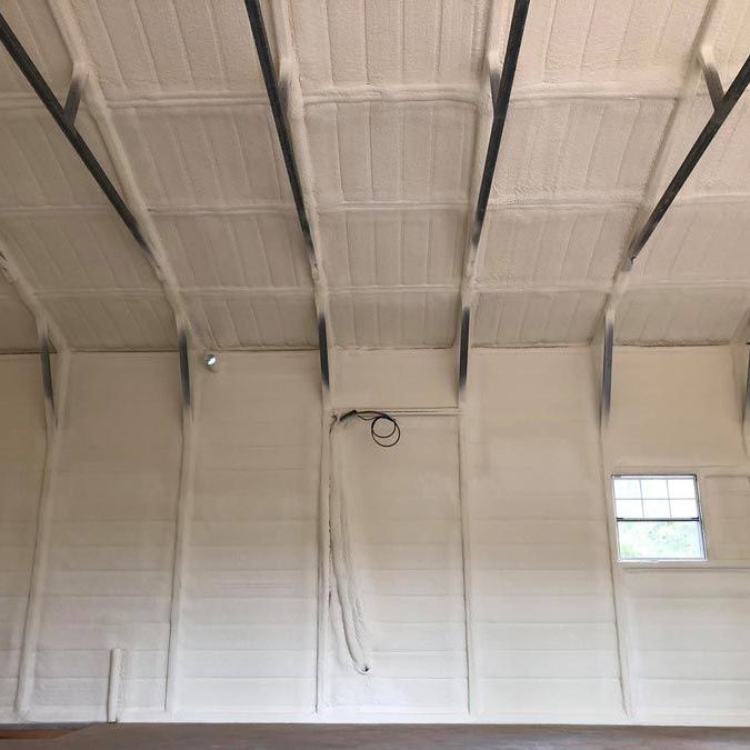 The ceiling of a building with white walls and a window.