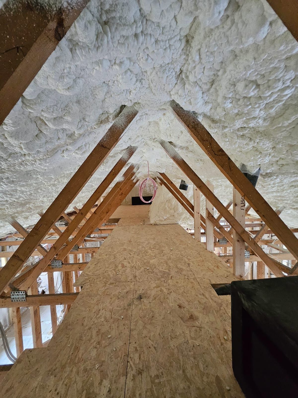 Looking up at the ceiling of an attic covered in foam.