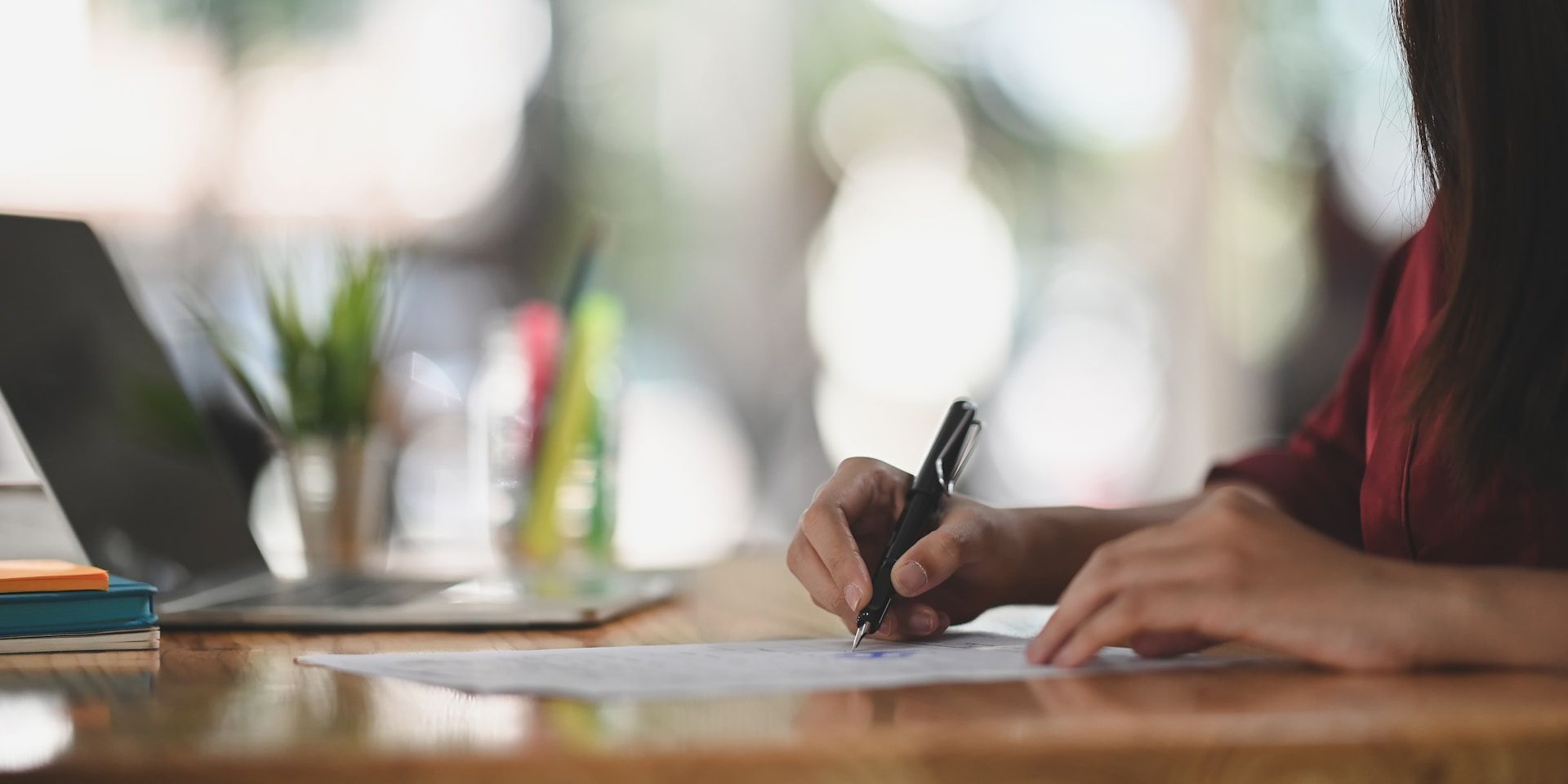A man with a backpack is standing next to a lake in the woods.