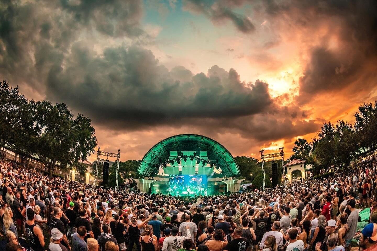 A crowd of people are standing in front of a stage at a concert.