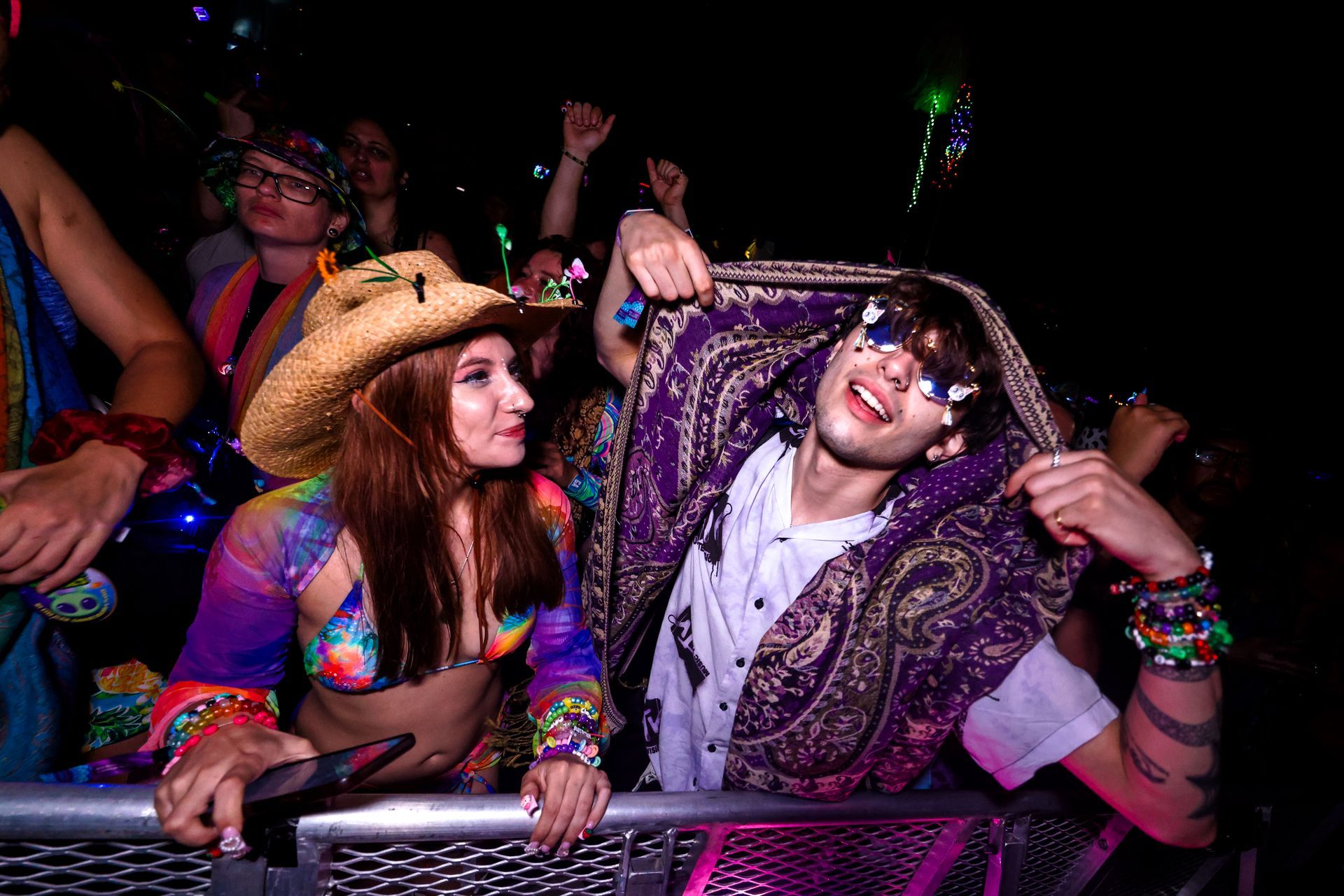 A man and a woman are standing next to each other at a concert.