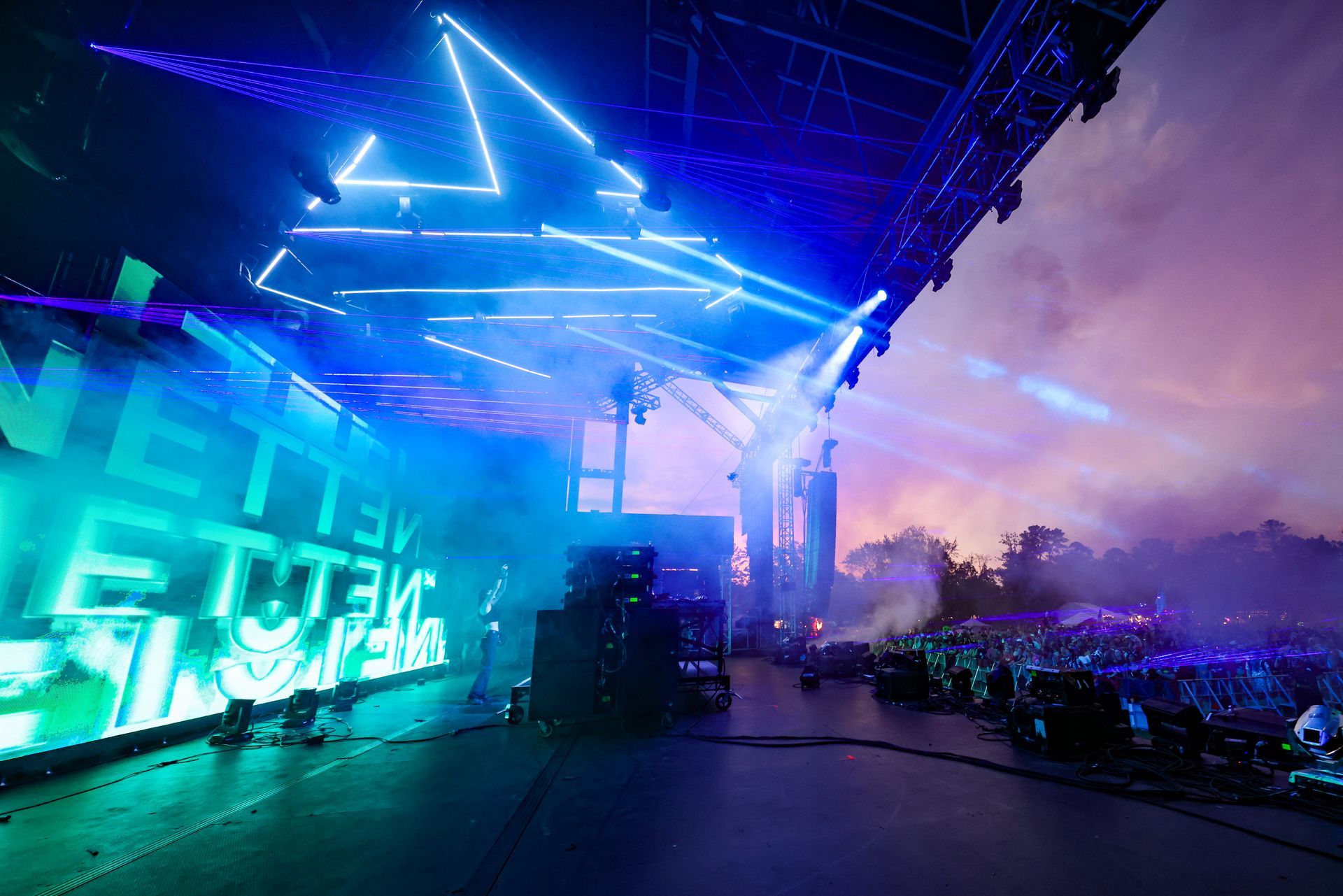 A large crowd of people are watching a concert on a stage.