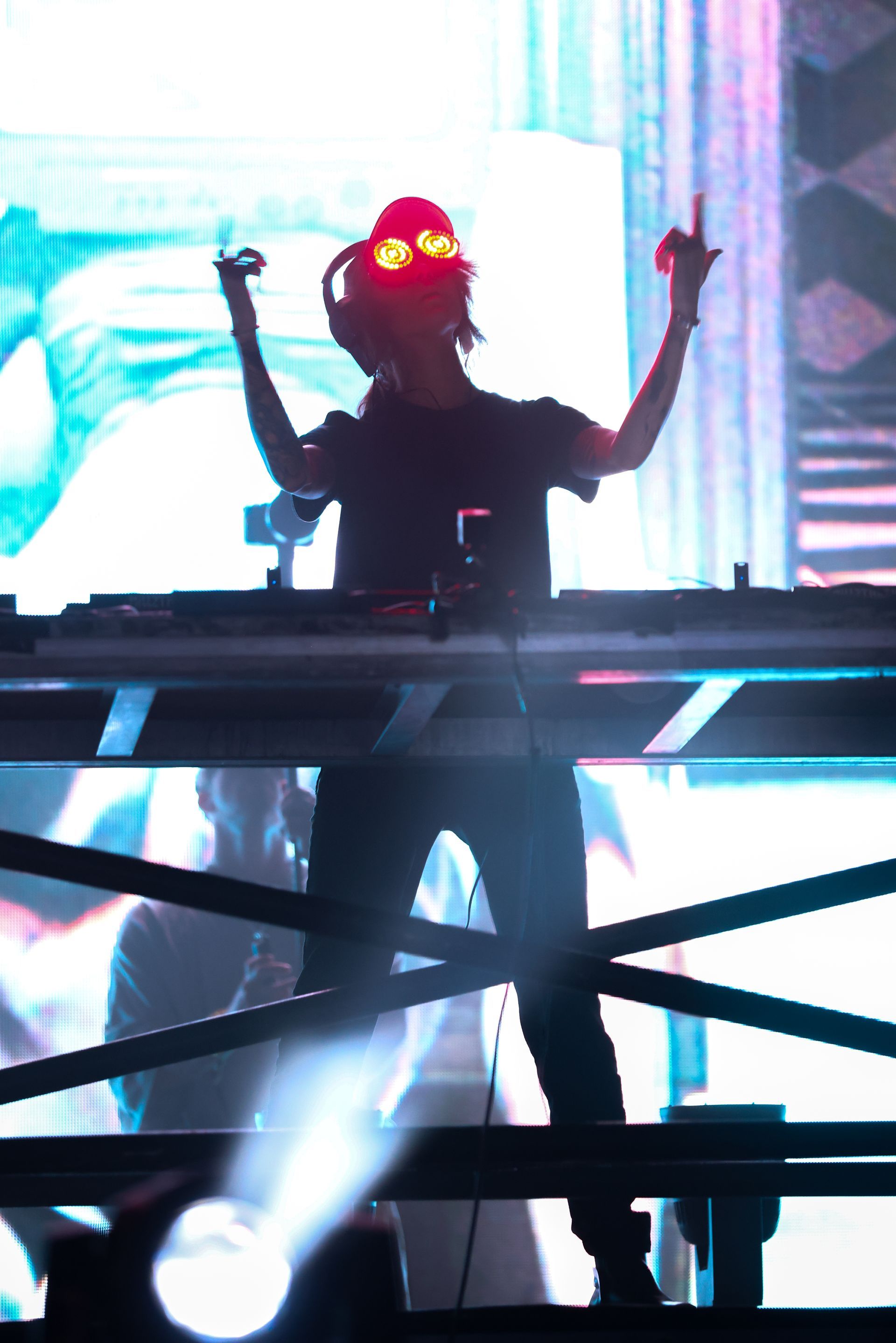 A dj is standing on a stage with his arms outstretched