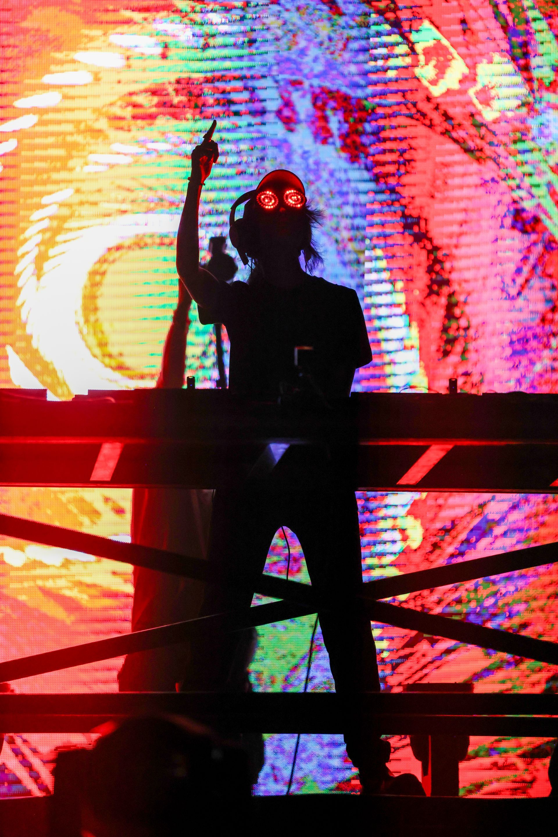 A man is standing on a stage in front of a colorful screen.