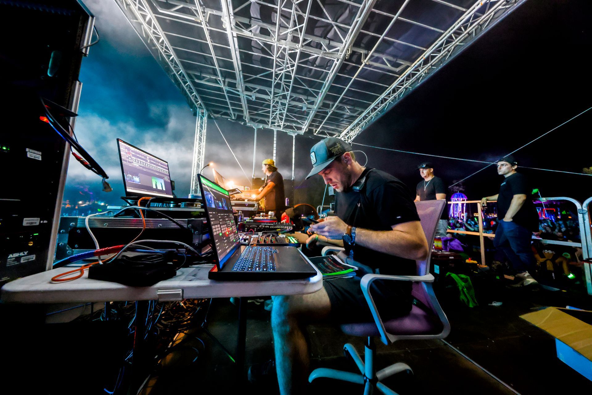 A man is sitting at a desk in front of a laptop computer.