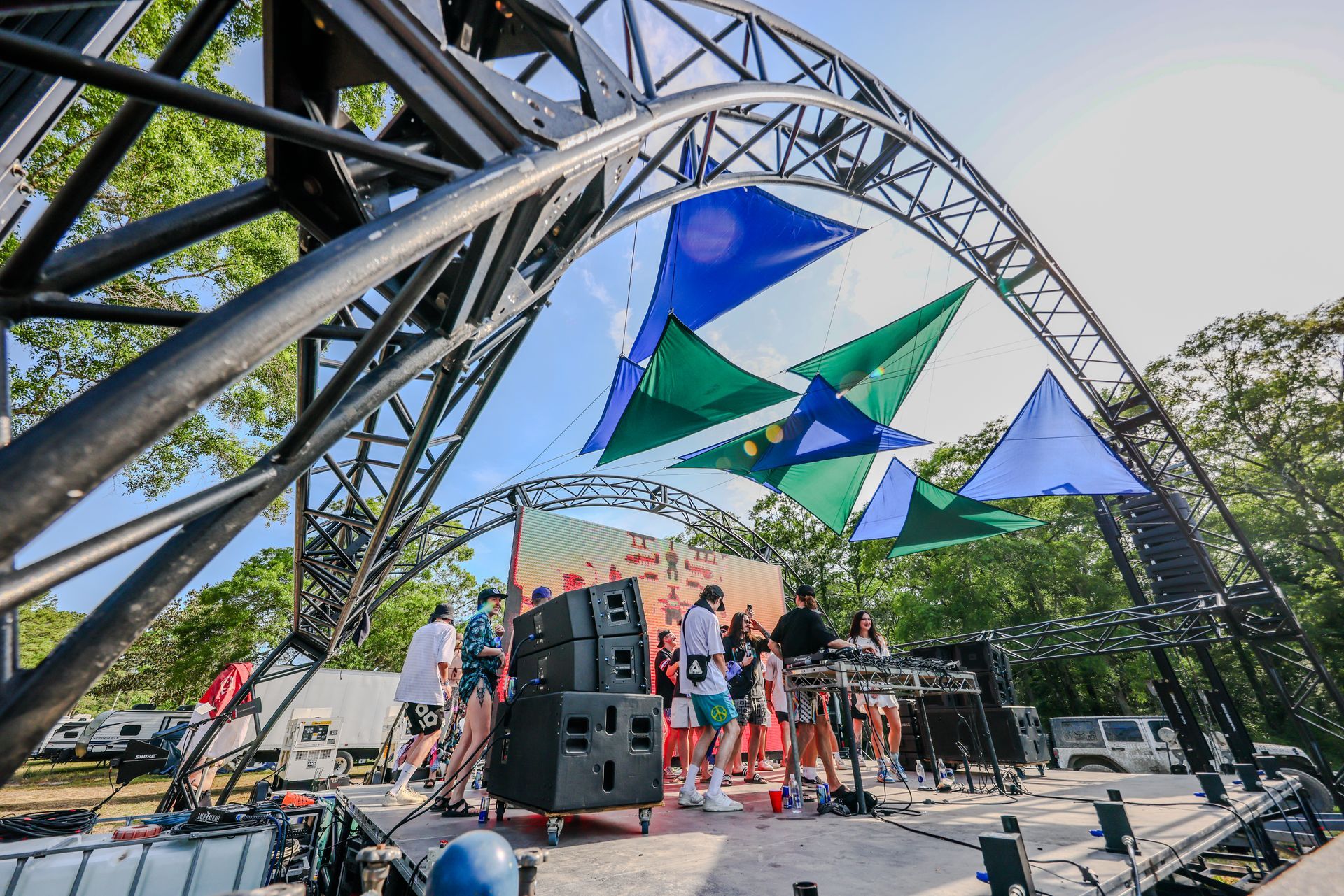 A group of people are standing on a stage in front of a large metal structure.