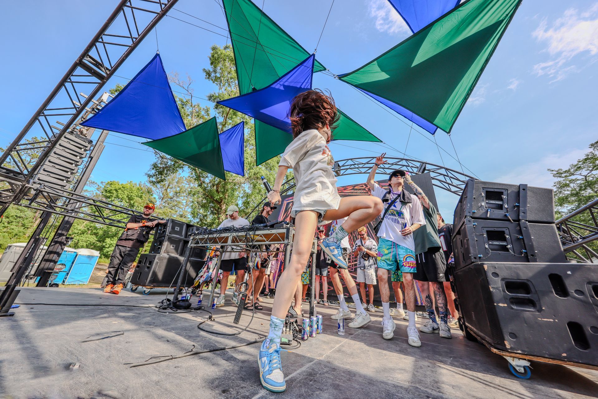 A woman is dancing on a stage at a music festival.